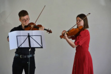 Ein Mann und eine Frau spielen auf Streichinstrumenten (Geige) 